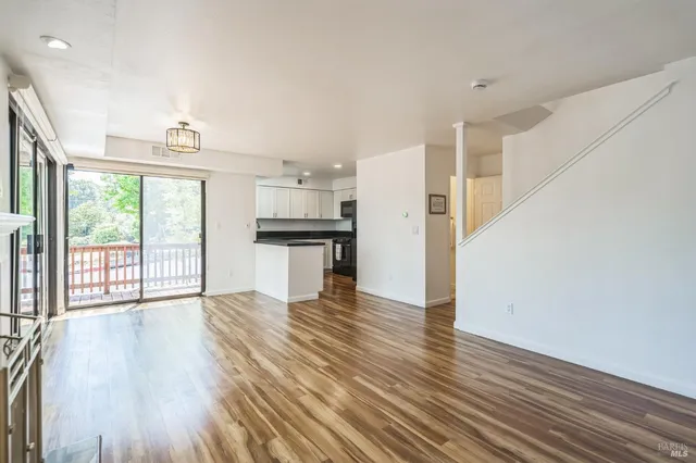 a view of empty room with wooden floor and fireplace