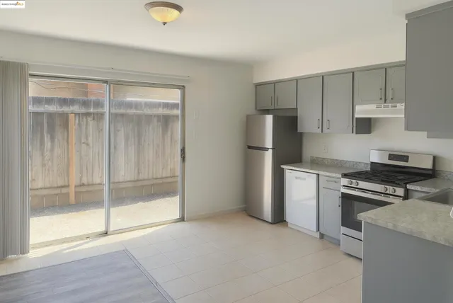 a kitchen with a refrigerator and a stove top oven