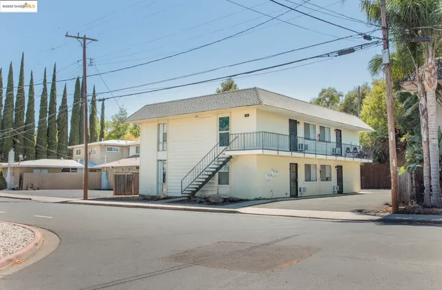 a front view of a building with cars parked