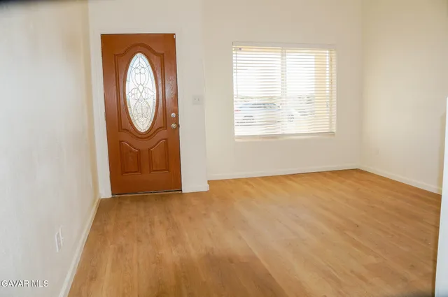 an empty room with wooden floor and a window