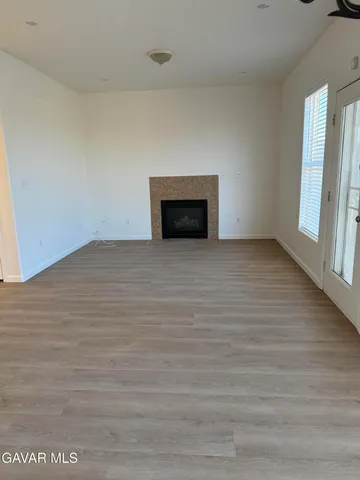 a view of empty room with wooden floor and fireplace