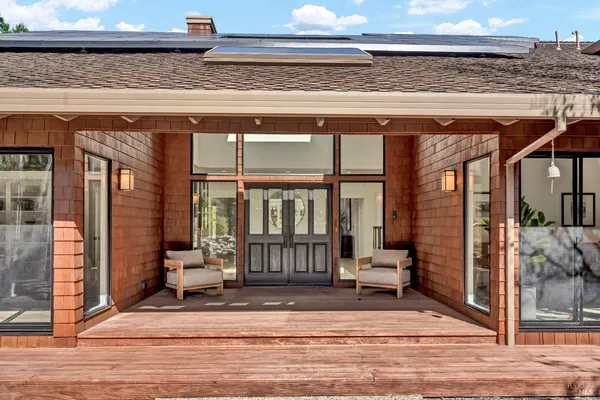 a view of backyard with deck and outdoor seating