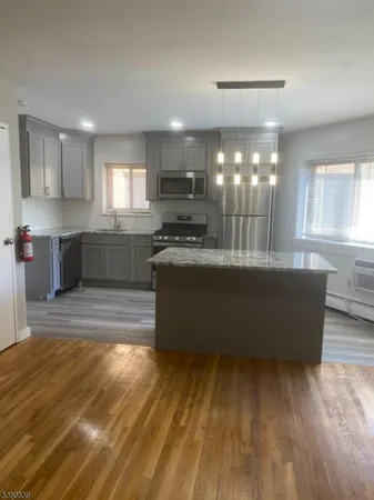 a large kitchen with kitchen island a sink wooden floor and glass counter space
