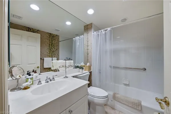 a bathroom with a sink toilet a mirror and shower