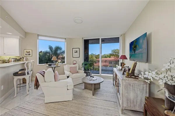 a living room with furniture a rug and a flat screen tv