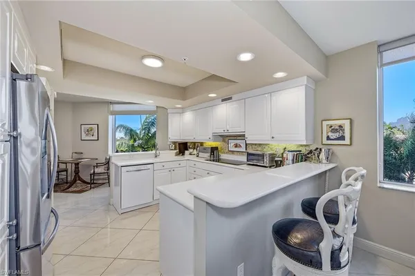 a kitchen with a sink a stove and chairs