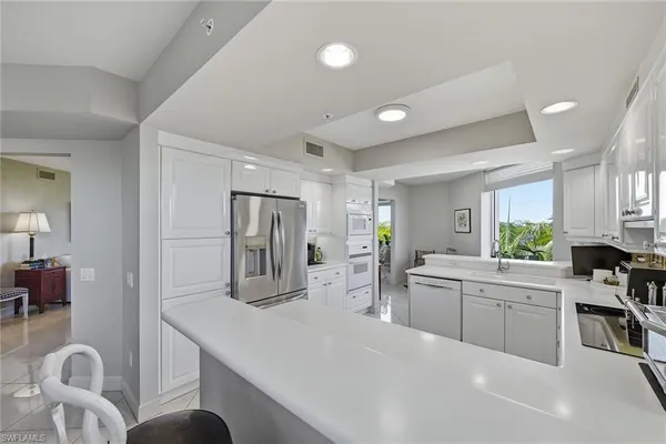 a kitchen with granite countertop a sink cabinets and stainless steel appliances