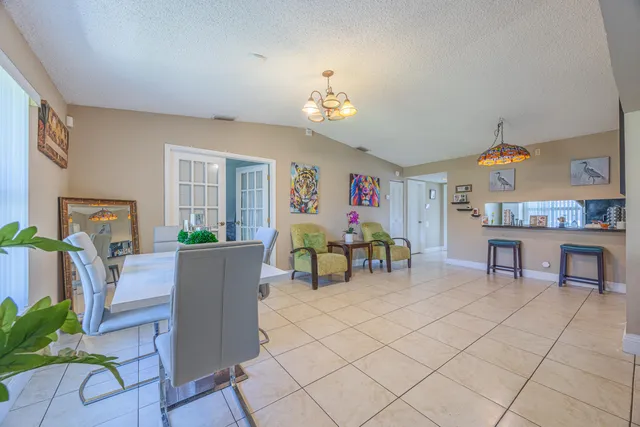 a living room with furniture and a dining table with chairs