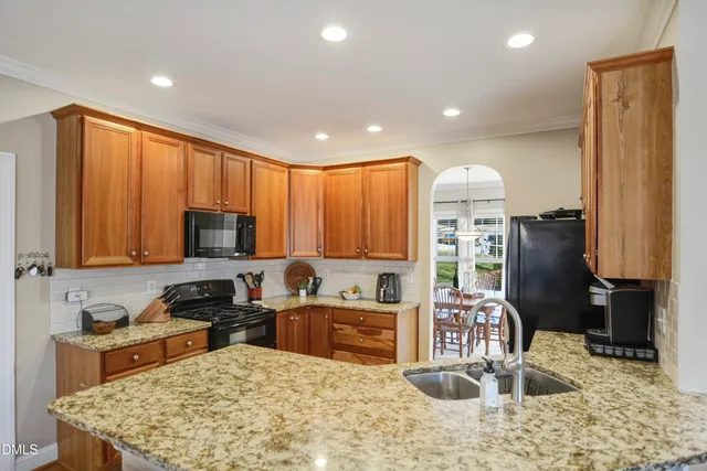a kitchen with stainless steel appliances granite countertop a sink stove and refrigerator