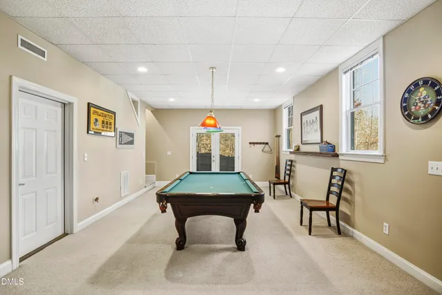 a room with furniture pool table and window