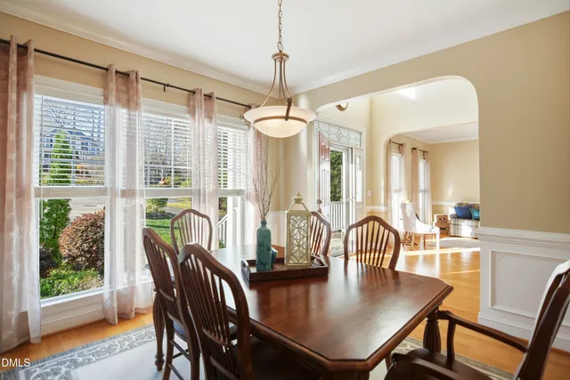 a dining room with furniture a chandelier and wooden floor