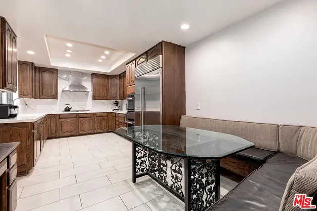 a kitchen with stainless steel appliances kitchen island granite countertop a sink and a refrigerator