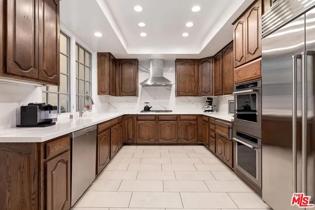 a kitchen with stainless steel appliances granite countertop a sink refrigerator and cabinets