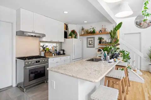 a kitchen with a stove and a white cabinets