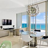 a living room with furniture a flat screen tv and a floor to ceiling window