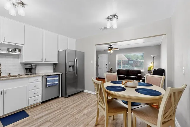 a kitchen with a table chairs and a refrigerator