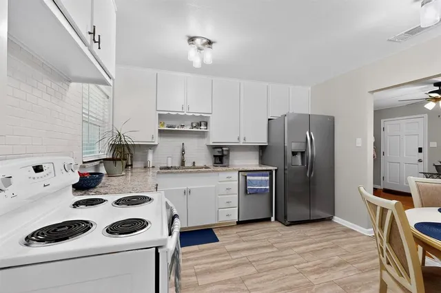 a kitchen with a refrigerator a stove a sink dishwasher and wooden floor