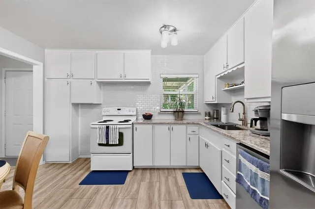 a kitchen with stainless steel appliances granite countertop a sink stove a refrigerator and cabinets