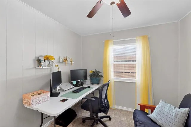 a view of a workspace with furniture and a window
