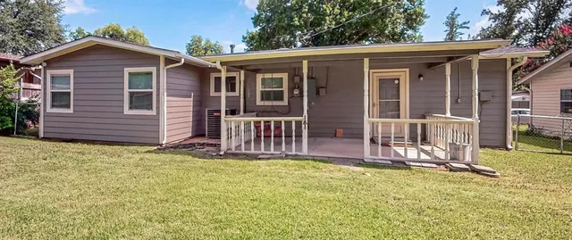 a view of a house with wooden deck and a yard