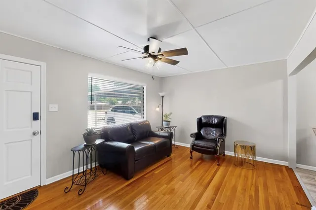 a living room with furniture and a wooden floor