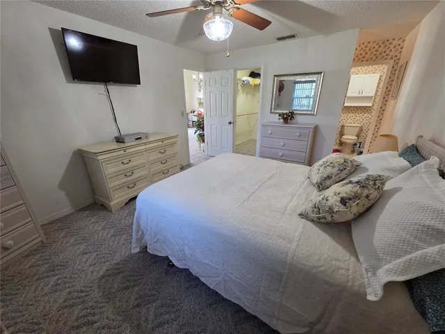 a bedroom with a bed and a flat tv screen on dresser