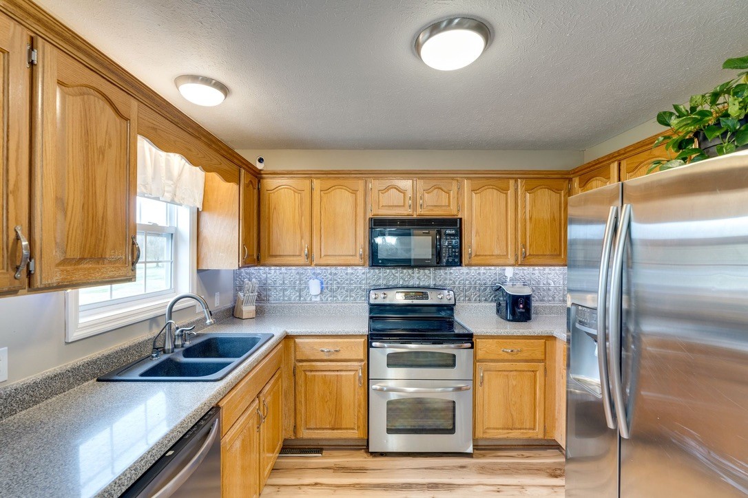 365 Corinth Road Portland, TN 37148 - Photo 7 of 20 a kitchen with stainless steel appliances granite countertop a refrigerator a stove top oven a sink and dishwasher