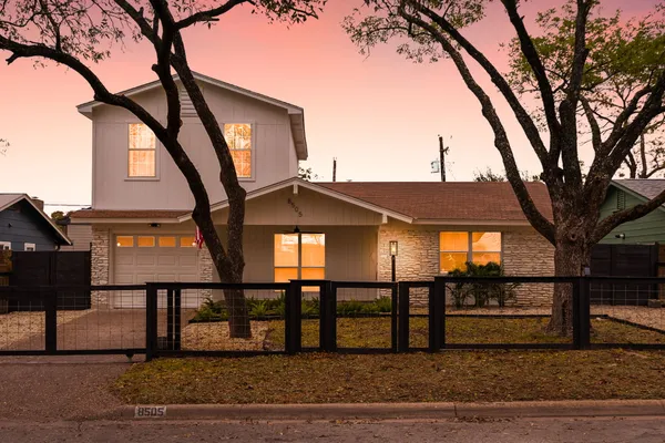 a front view of a house with a tree