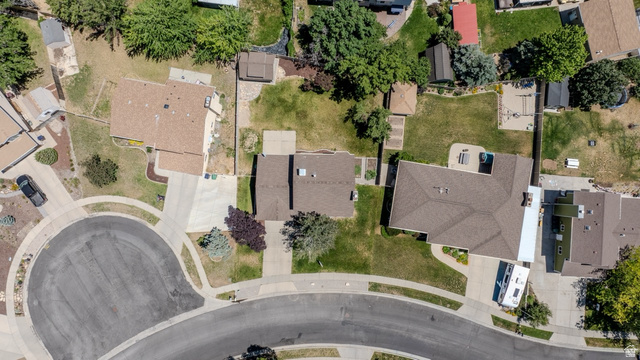 11957 Noelle Road Sandy, UT 84092 - Photo 34 of 38 Overhead view of a residential property featuring a brown shingle roof, concrete driveway, and a large backyard with mature trees