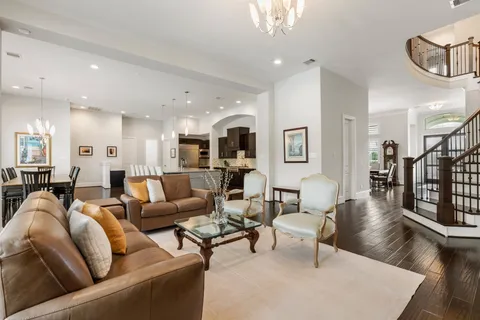 a living room with furniture kitchen view and a wooden floor