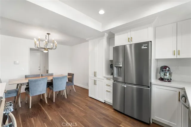 a kitchen with stainless steel appliances a refrigerator a stove a dining table and chairs