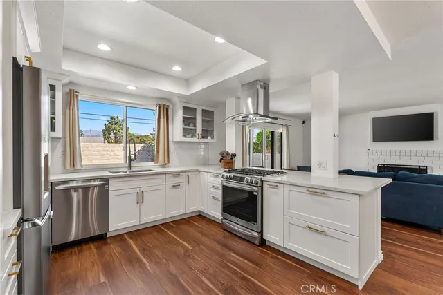 a kitchen with stainless steel appliances granite countertop hardwood a sink stove and refrigerator