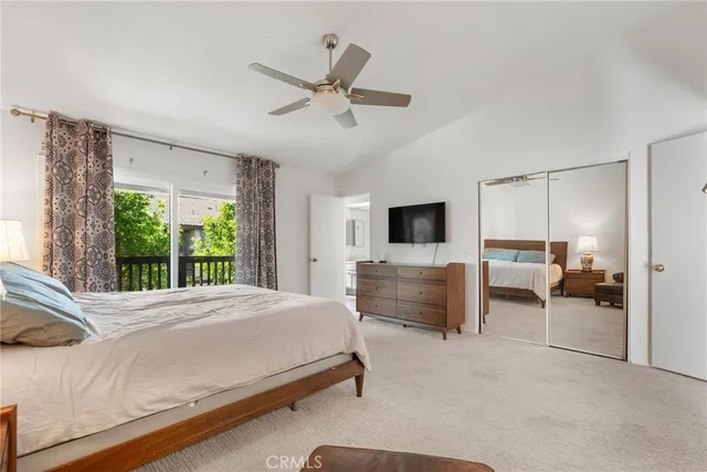 a bedroom with a bed flat screen tv and a large window