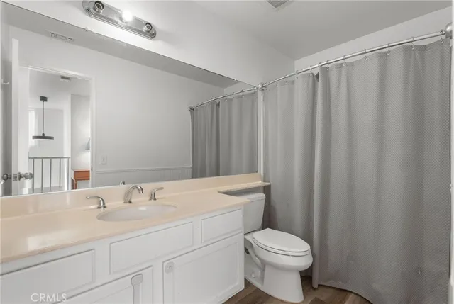 a bedroom with a bed chandelier and a window