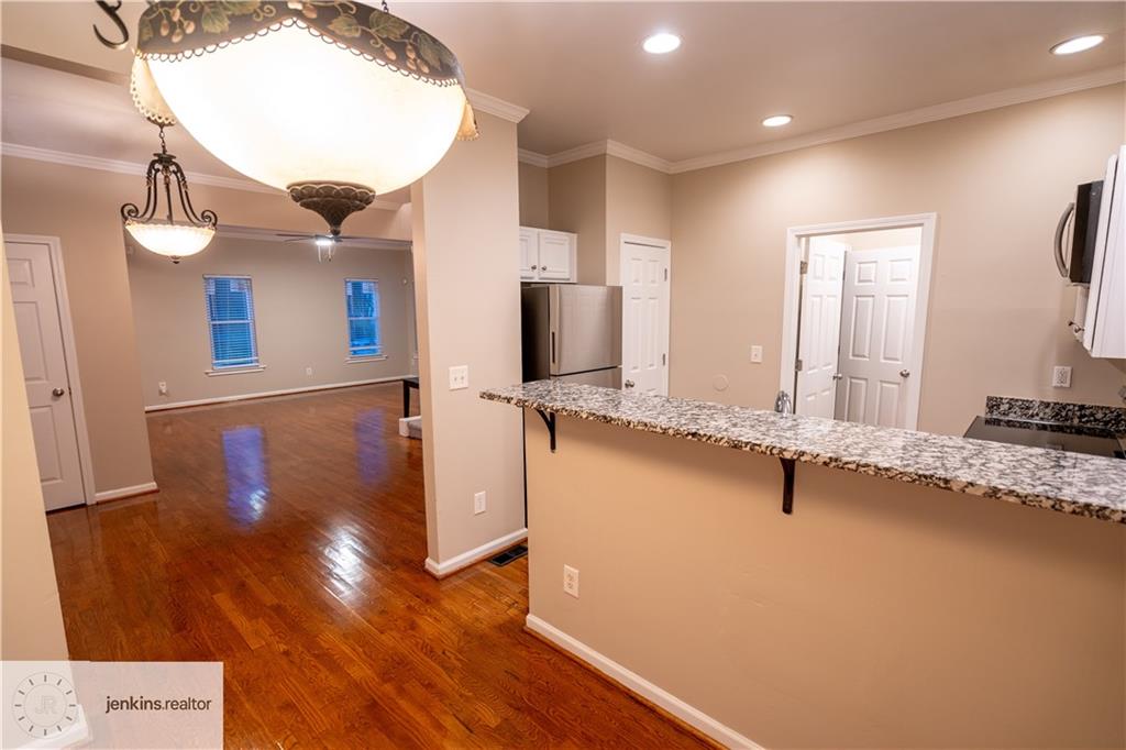 1188 Ira Street Southwest Atlanta, GA 30310 - Photo 12 of 33 a view of a kitchen with kitchen island a sink wooden floor and a counter top space