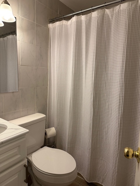 100 Rising Trail Drive, Unit 100 Middletown, CT 06457 - Photo 14 of 33 a white toilet sitting next to a shower curtain