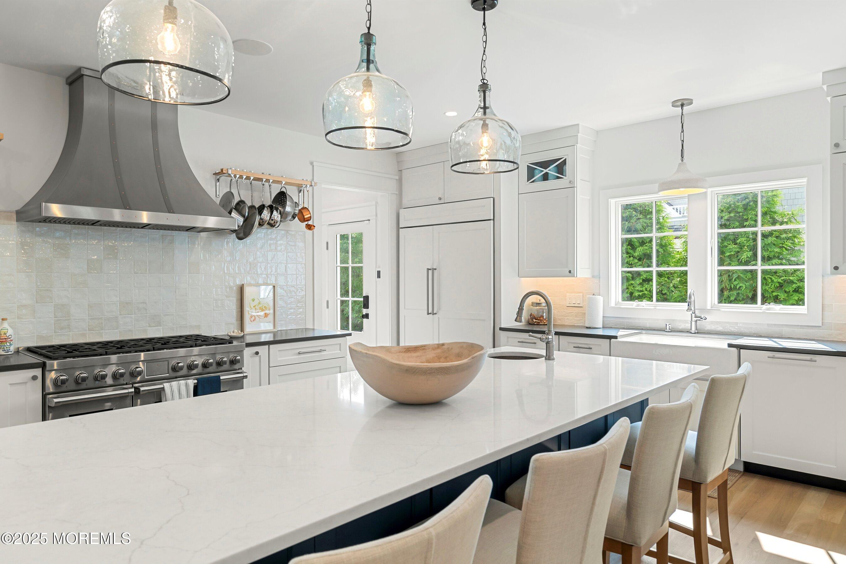205 Morris Avenue Spring Lake, NJ 07762 - Photo 102 of 105 a kitchen with stainless steel appliances a table a stove and a wooden floors