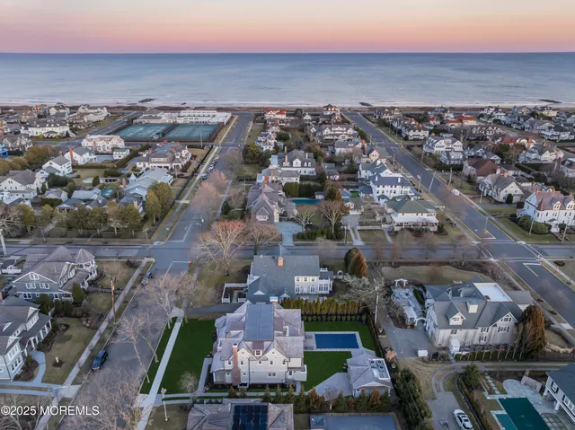 a view of a hallway with wooden floor and a bathroom