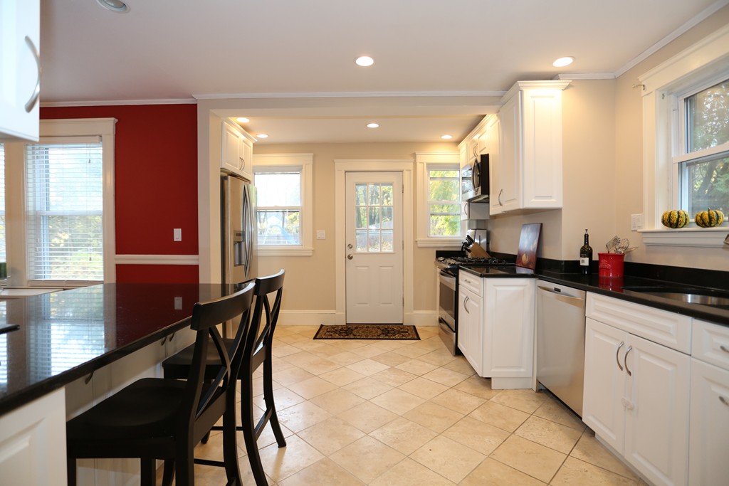 275 Broad Meadow Road Needham, MA 02492 - Photo 8 of 26 a kitchen with sink a table and chairs in it