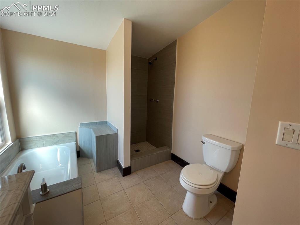 7540 Boone Road Yoder, CO 80864 - Photo 5 of 31 a white toilet sitting next to a bathroom sink and a mirror