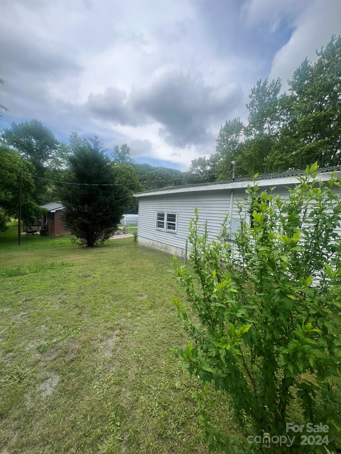 1323 Locust Grove Road Hendersonville, NC 28792 - Photo 5 of 40 a backyard of a house with lots of green space and lake view