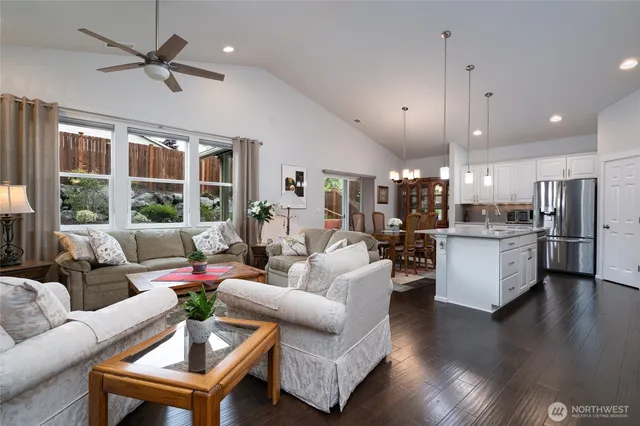 a living room with furniture kitchen and a large window