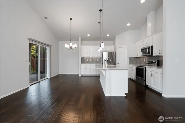 a view of kitchen with cabinets wooden floor and a sink