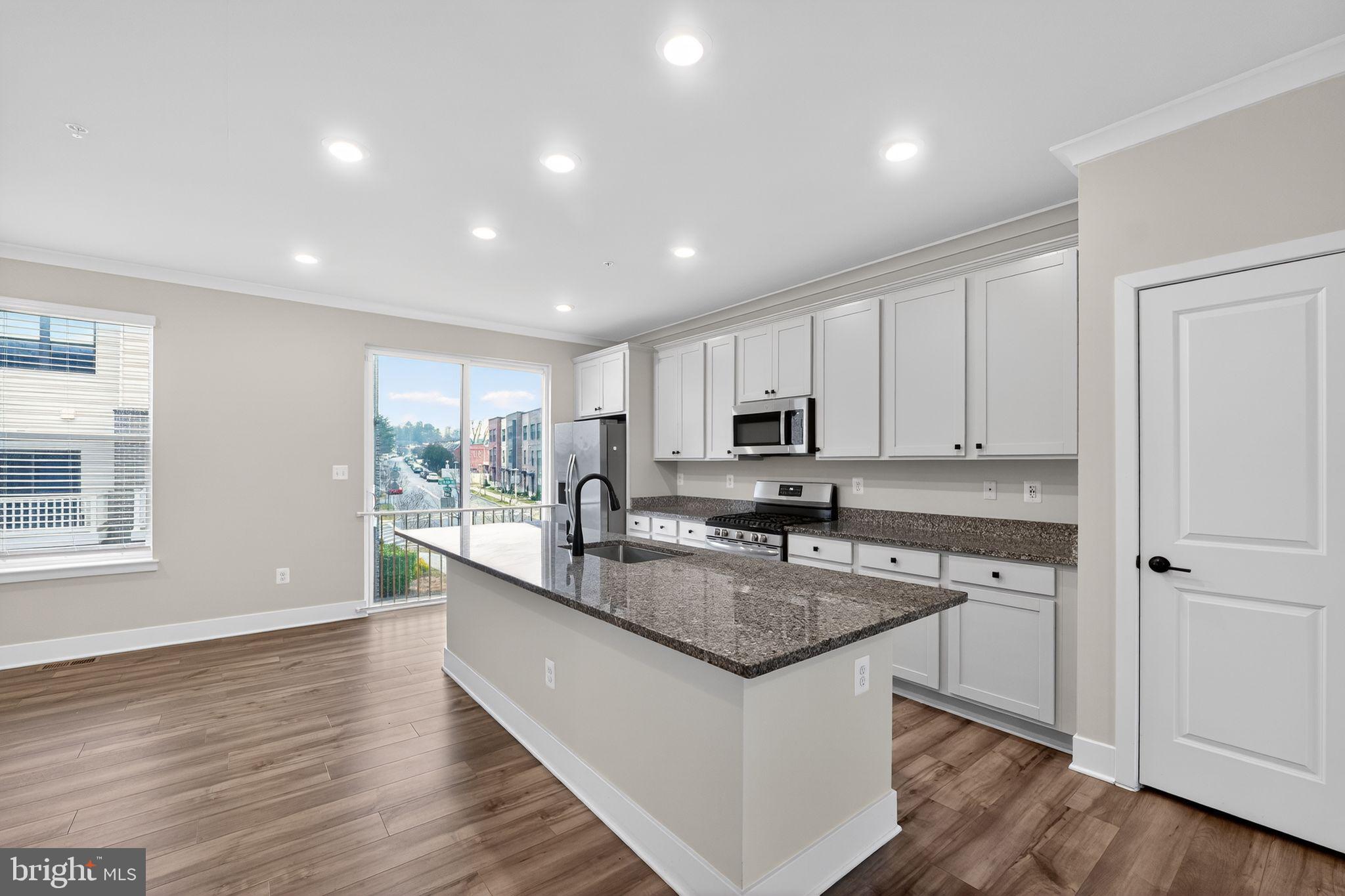 4300 Roland Heights Avenue Baltimore, MD 21211 - Photo 12 of 37 a kitchen with stainless steel appliances granite countertop a sink stove and cabinets