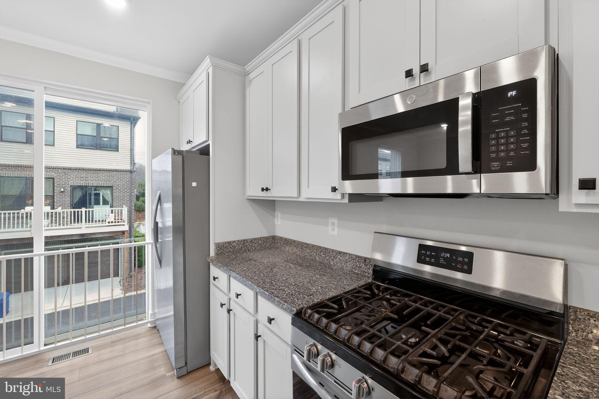 4300 Roland Heights Avenue Baltimore, MD 21211 - Photo 15 of 37 a kitchen with stainless steel appliances granite countertop a stove a refrigerator and a microwave