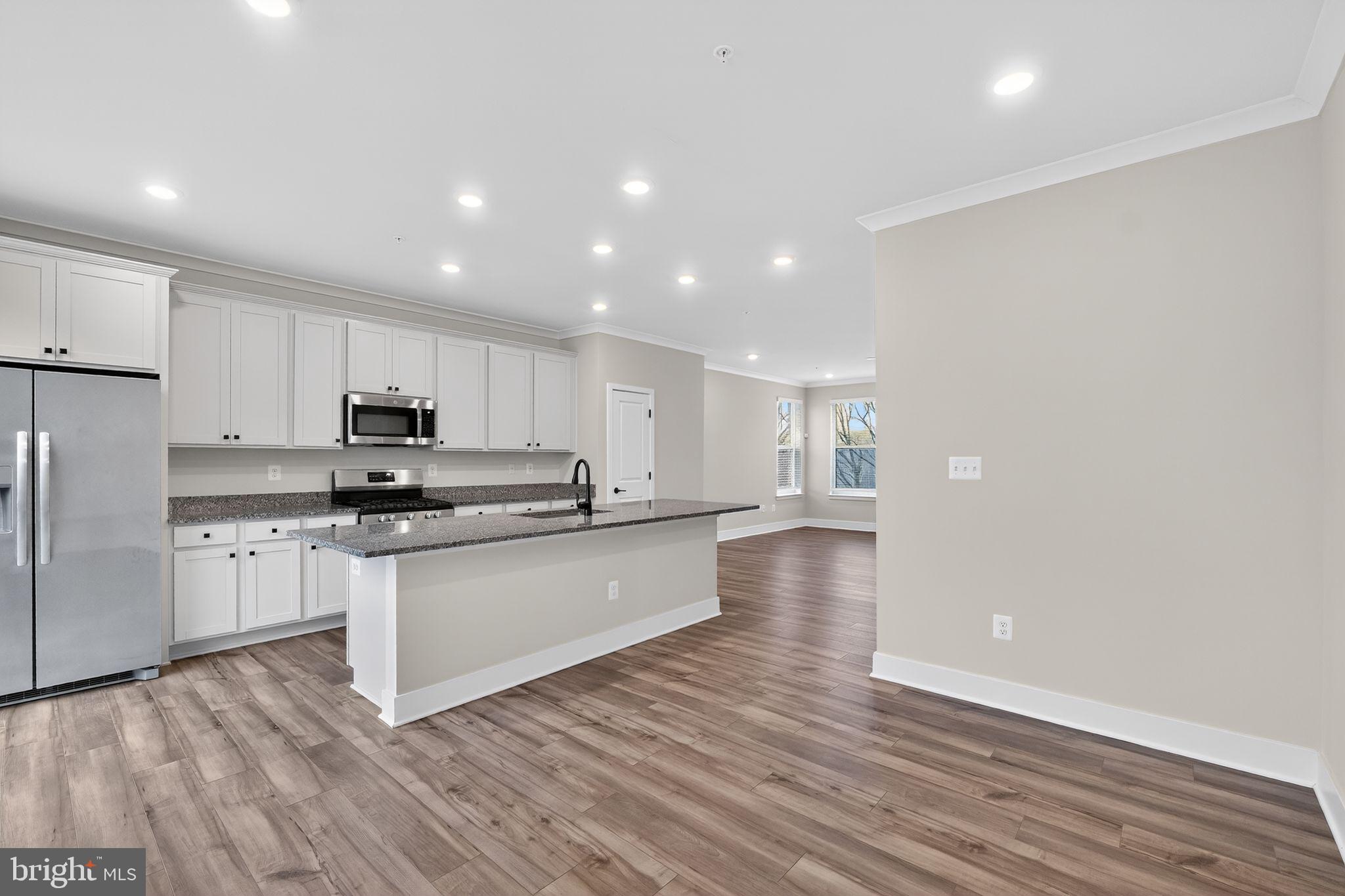 4300 Roland Heights Avenue Baltimore, MD 21211 - Photo 17 of 37 a kitchen with stainless steel appliances a refrigerator sink and white cabinets