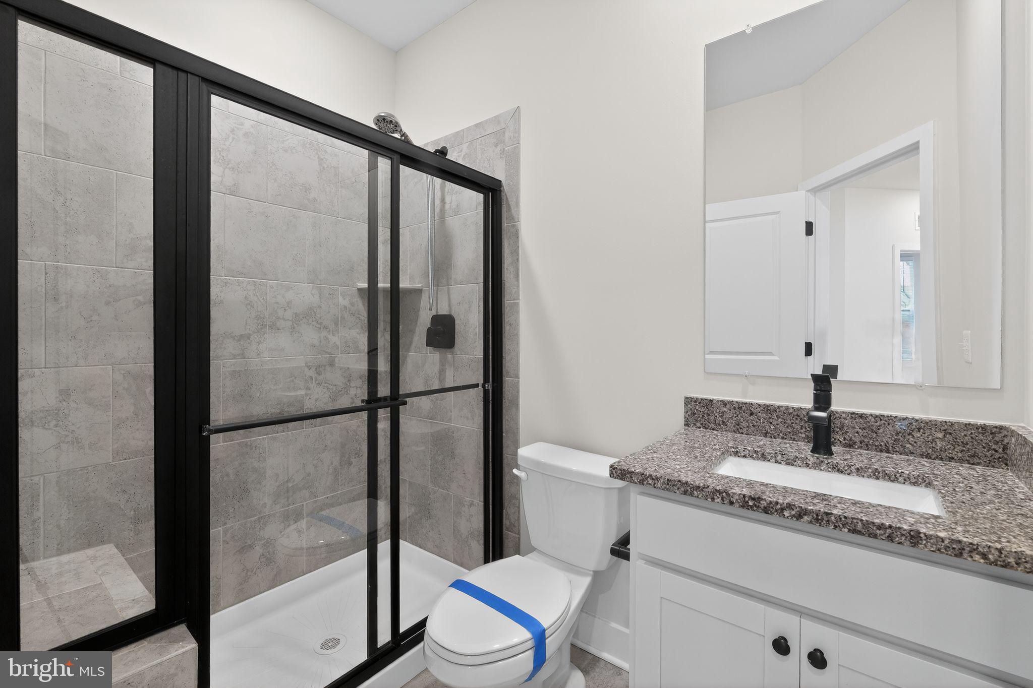 4300 Roland Heights Avenue Baltimore, MD 21211 - Photo 33 of 37 a bathroom with a granite countertop sink toilet and shower