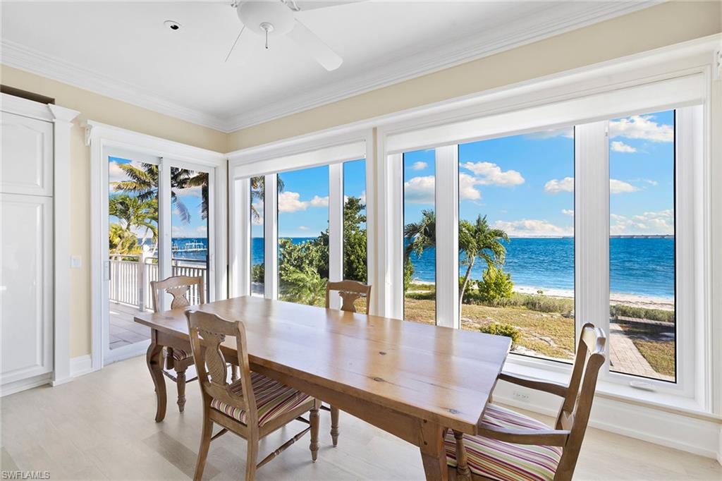 1069 Bird Lane Sanibel, FL 33957 - Photo 11 of 46 a view of a dining room with furniture large windows and wooden floor