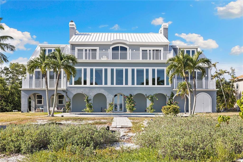 1069 Bird Lane Sanibel, FL 33957 - Photo 31 of 46 a front view of a house with a yard