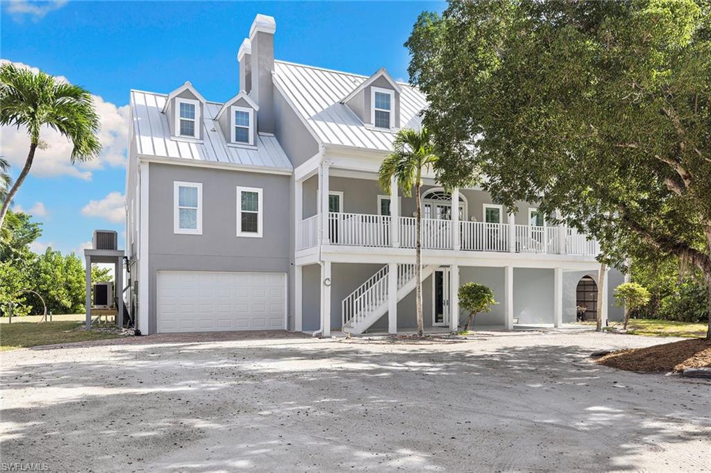 1069 Bird Lane Sanibel, FL 33957 - Photo 35 of 46 a front view of a house with a yard and garage
